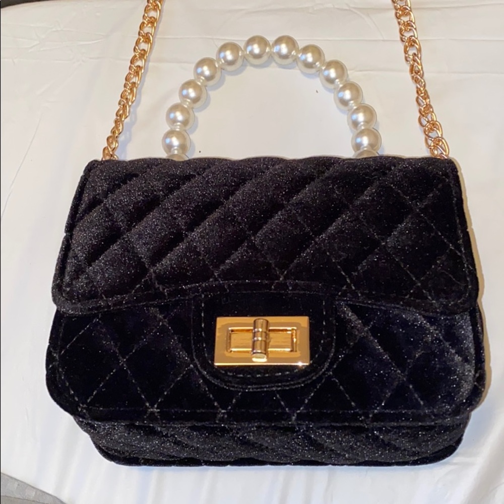 Black purse w pearl handle and a (gold chain).